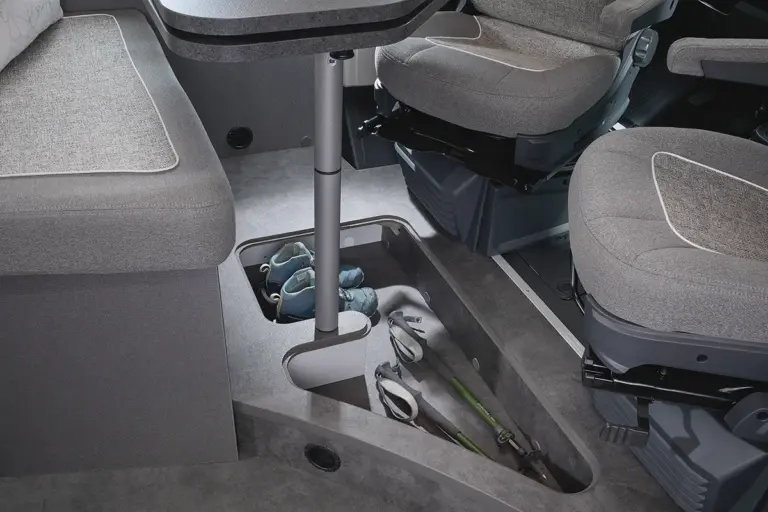 Stauraum im Fußboden des Malibu Van Relax mit Schuhen und Stöcken sichtbar.